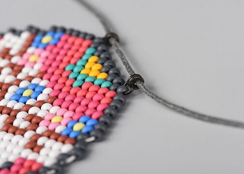 Closeup of the top of the candy skull, showing how the jump rings and necklace cord are attached